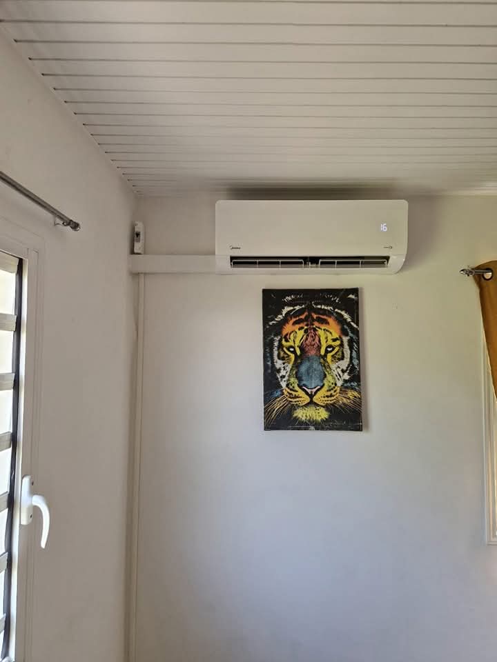 Installation Midea 9k BTU – Ducos – climatisation Martinique Installation Midea 9 000 BTU à Ducos : climatiseur mural fixé en partie haute d'un mur blanc, raccordé proprement par goulotte à un boîtier électrique – Ducos, Martinique – LD CLIM 972